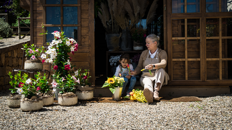 Kid with Rosewood Castiglion del Bosco florist creating a bouquet in a wooden house full of flowers and plants. 